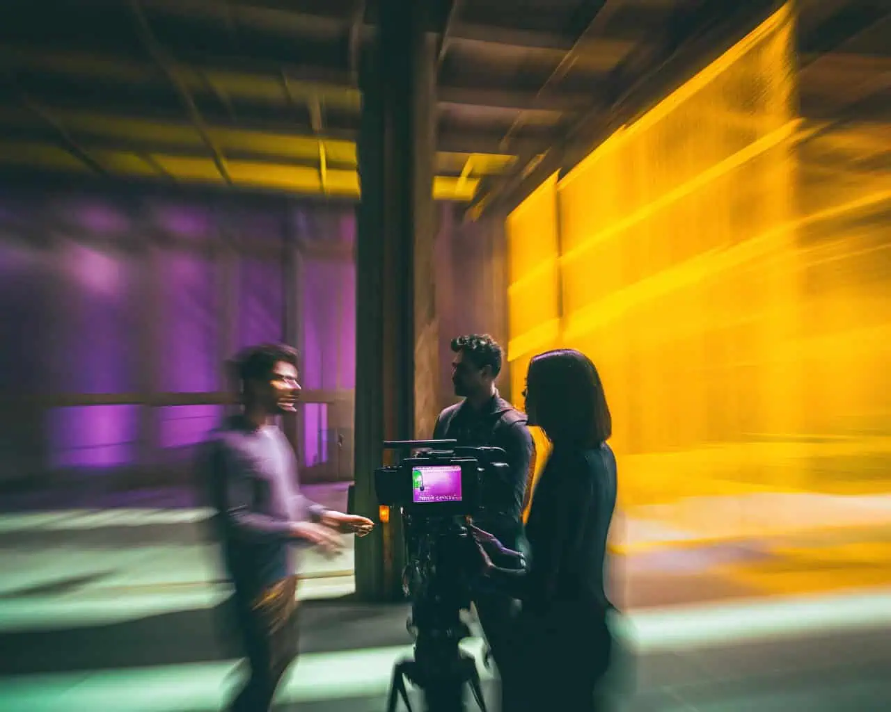 drie mensen staan rondom een camera