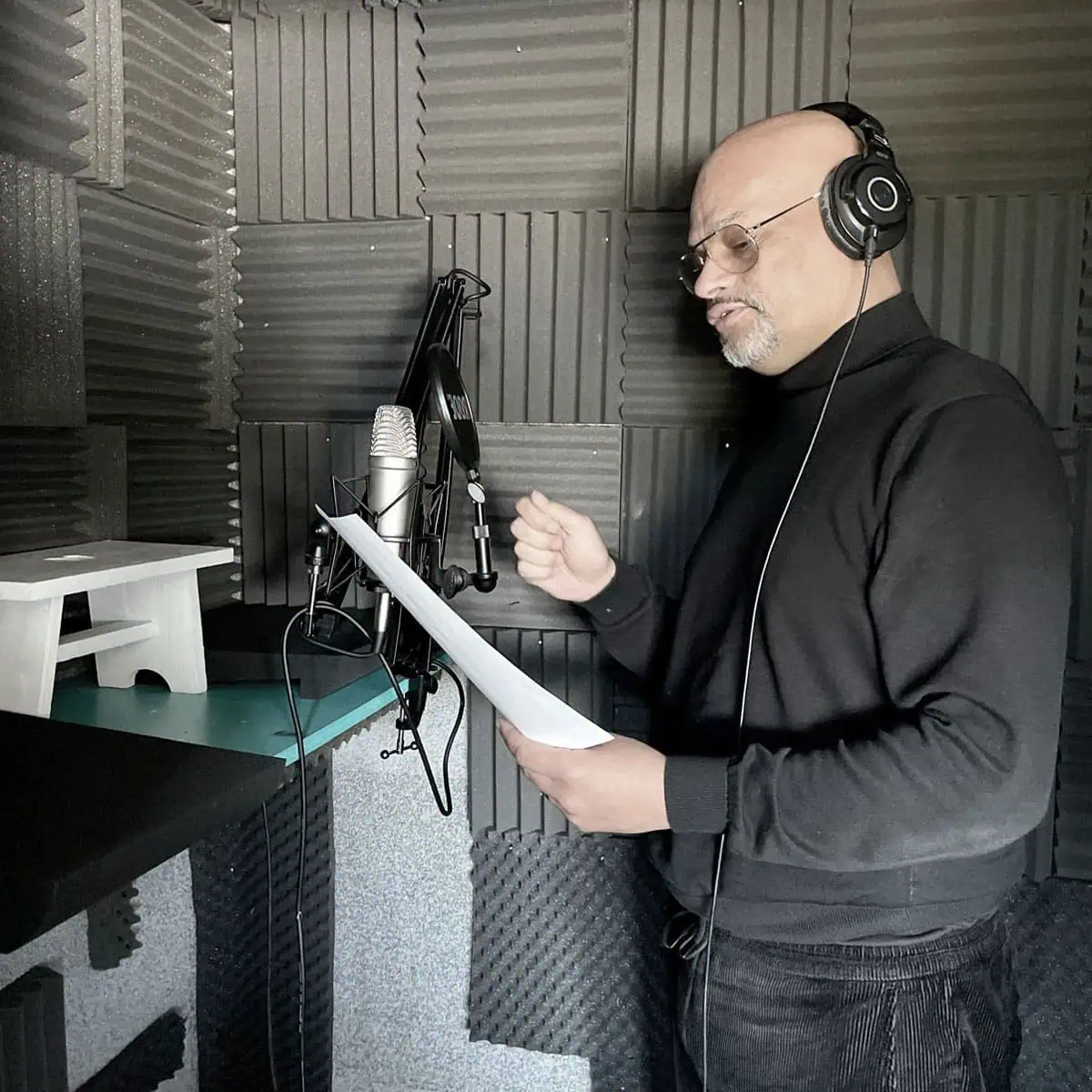 john in geluidsdichte kamer achter microfoon